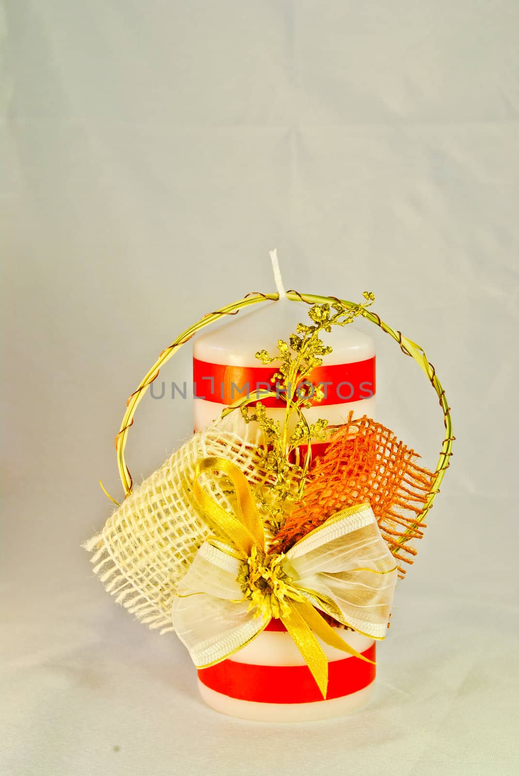 Red and white striped candle with a bow