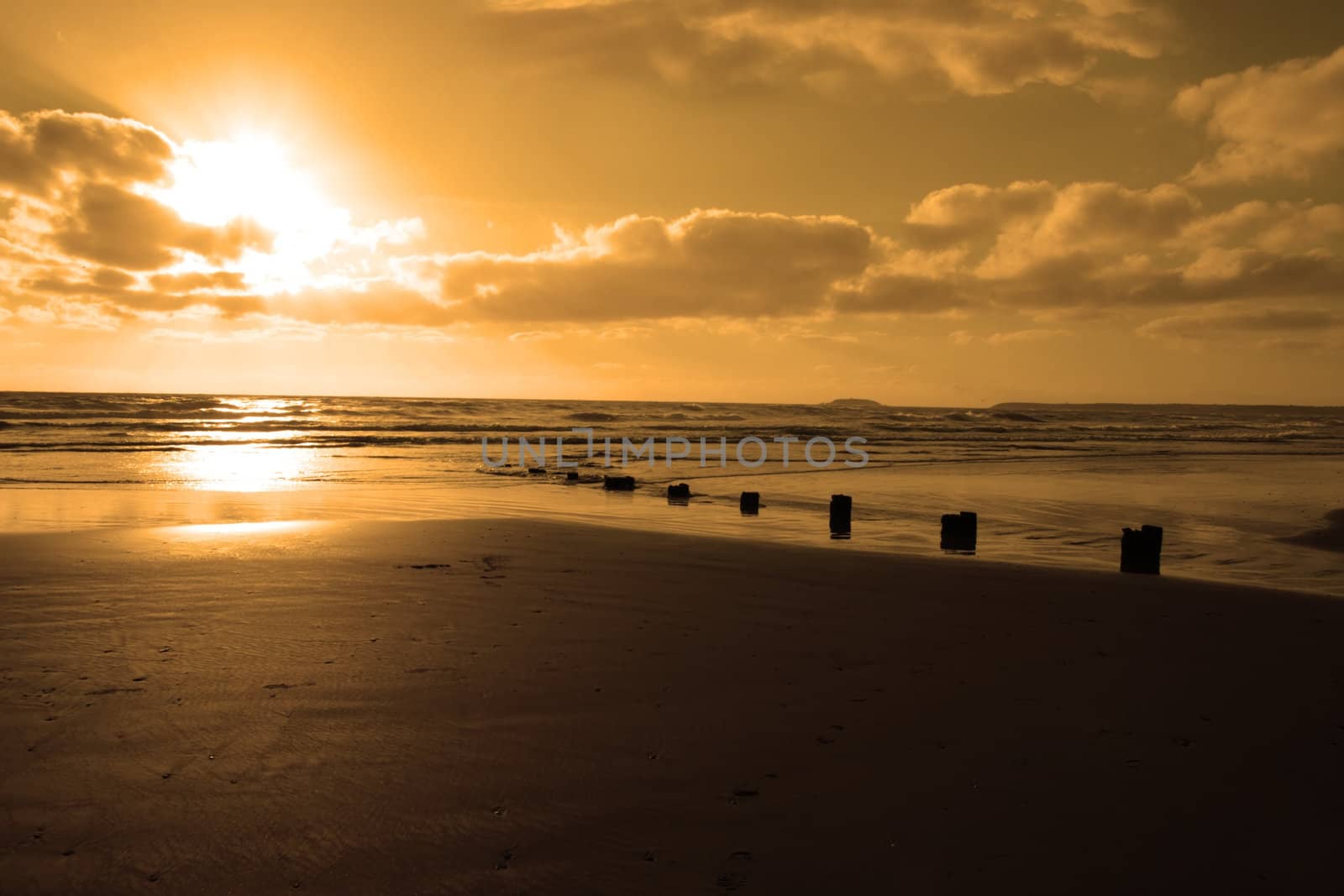 wave breakers at sunset on a golden beach in youghal county cork ireland