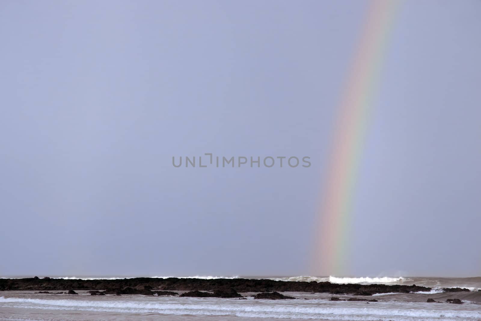 ballybunion beach and rocks with rainbow as a storm passes