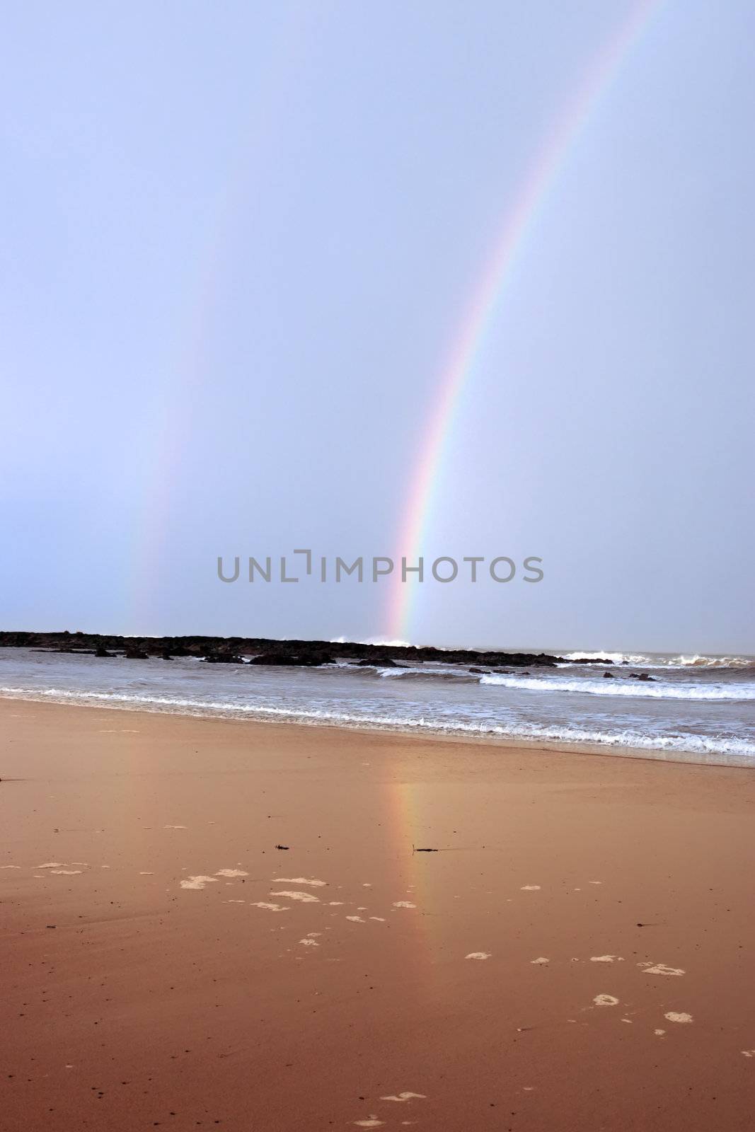 ballybunion beach and rocks with twin rainbows as a storm passes