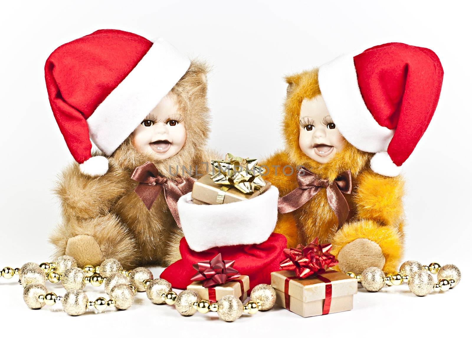 On a white background are two porcelain bears a Christmas gift bag and a golden ball strings.
