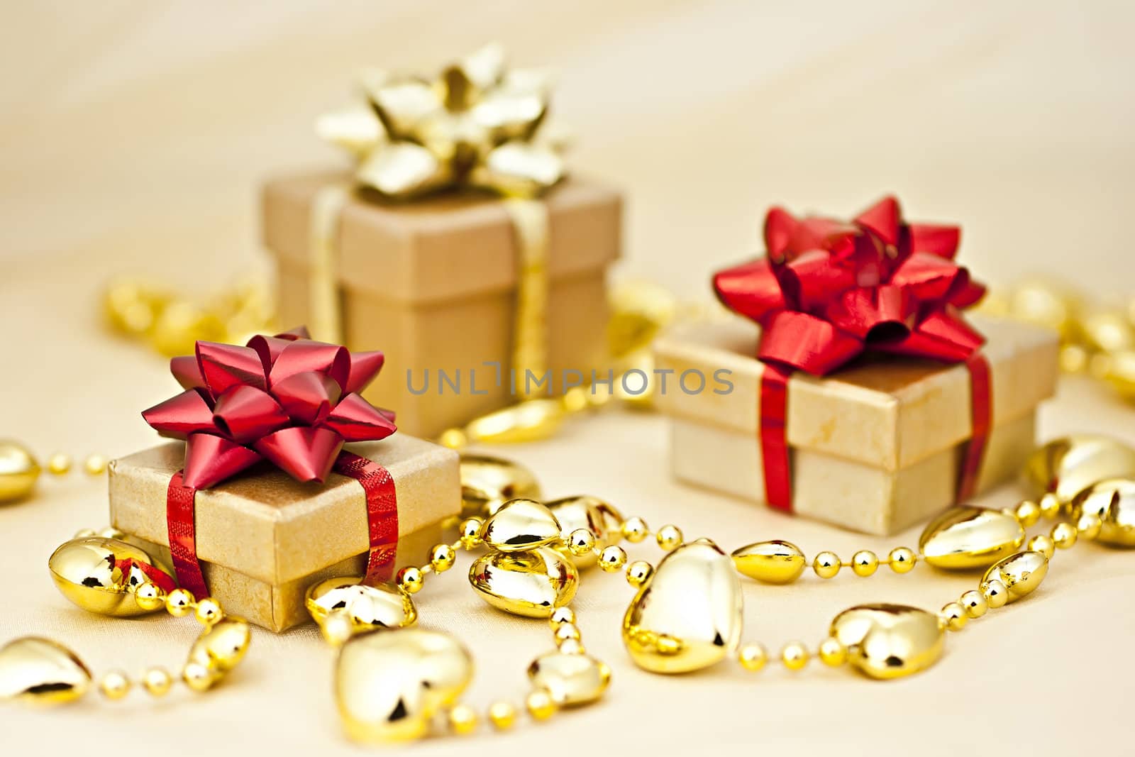 On the golden background gift box with a golden heart chain.
