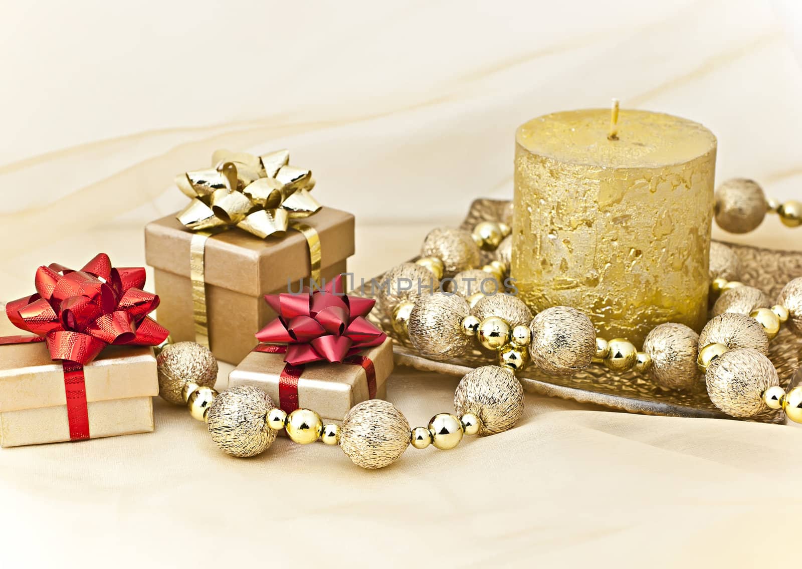 The gold background with a Christmas candle ball chains and gift boxes.
