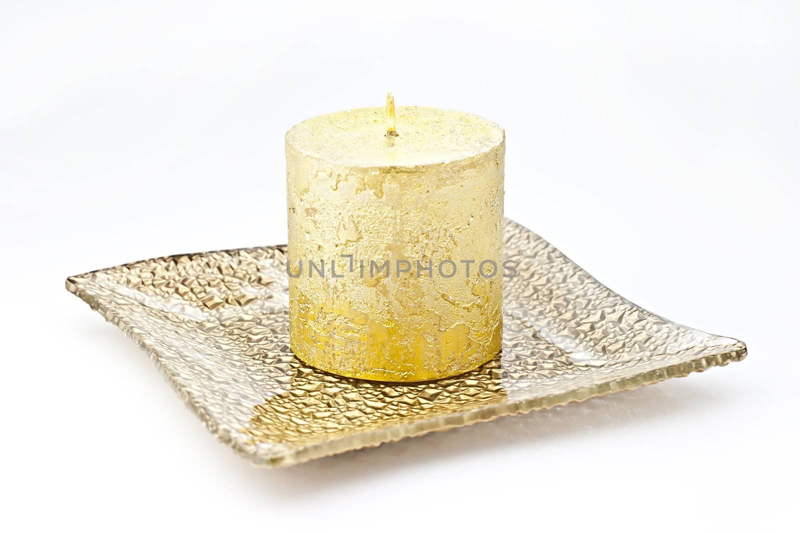 Isolated on white background gold candle in a glass dish.
