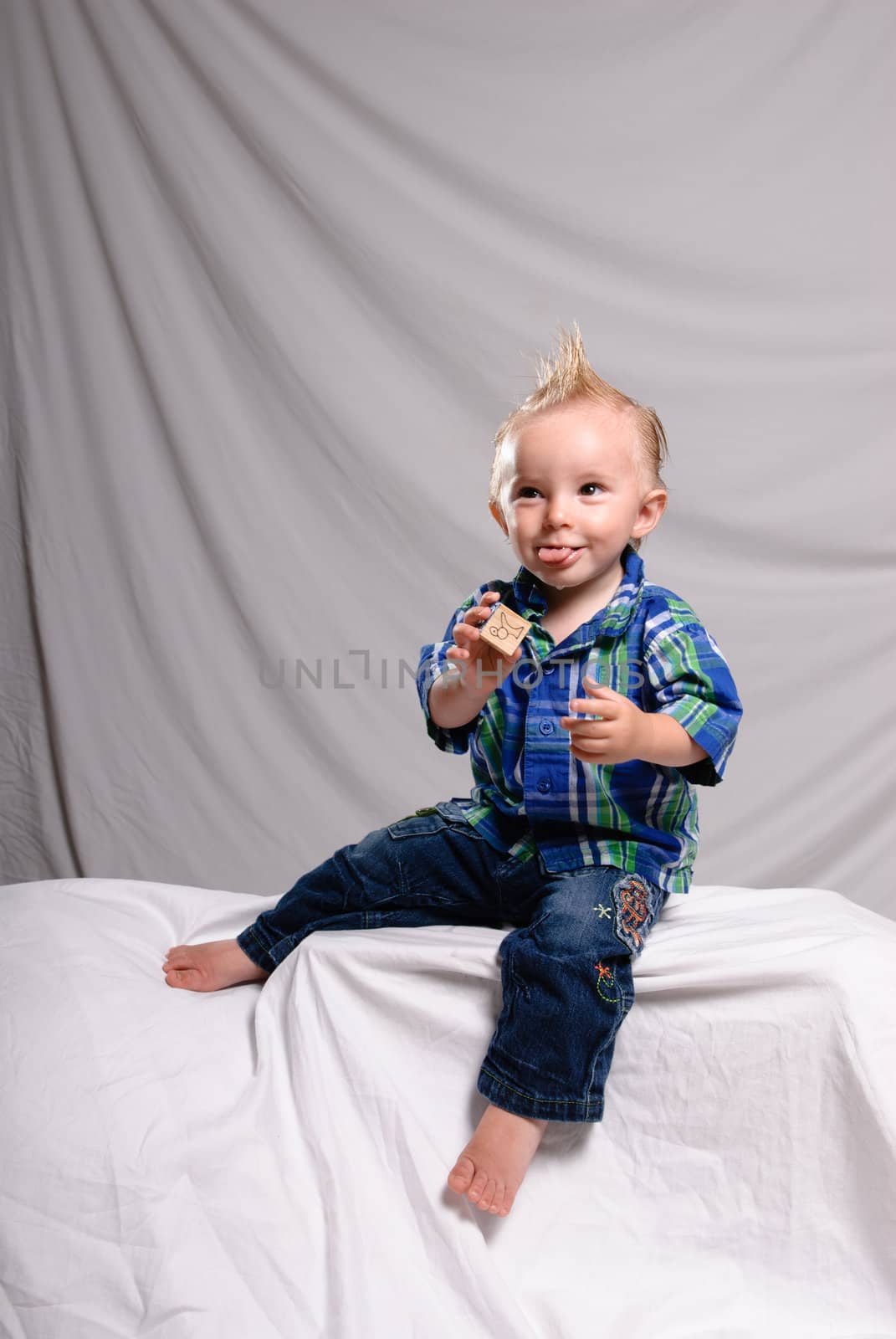 A young boy making a funny face while getting his portrait done