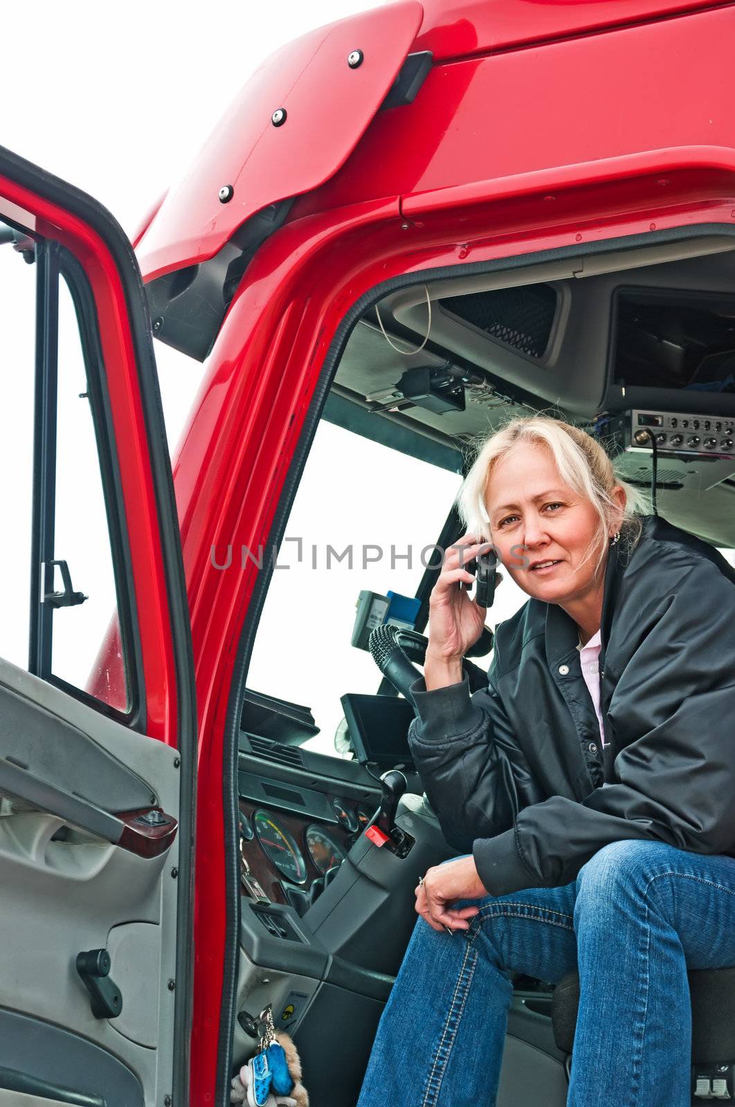 Pretty blonde truck driver getting directions to a delivery site on her cellphone.