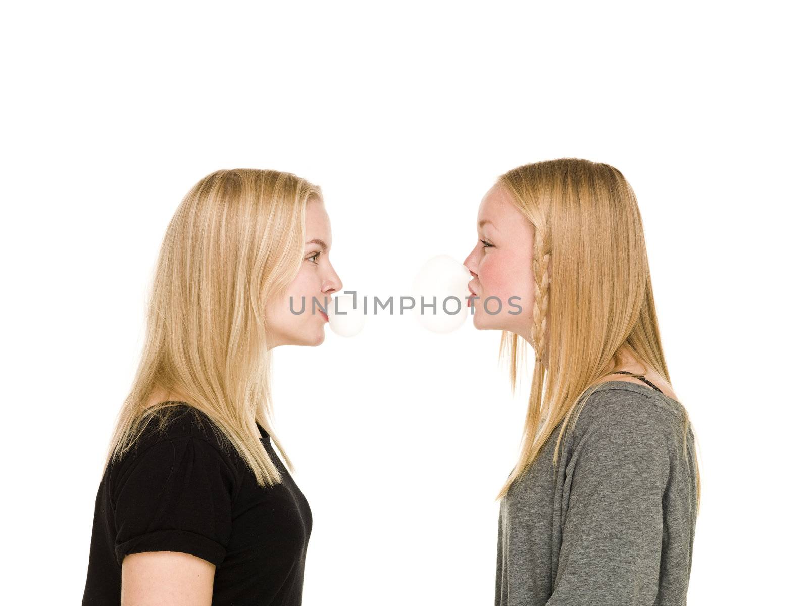 Two girls making bubbles of Bubble Gum isolated on white background