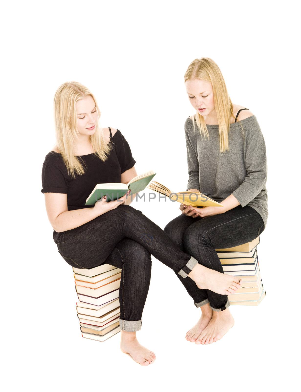 Girls sitting on piles of books reading isolated on white background