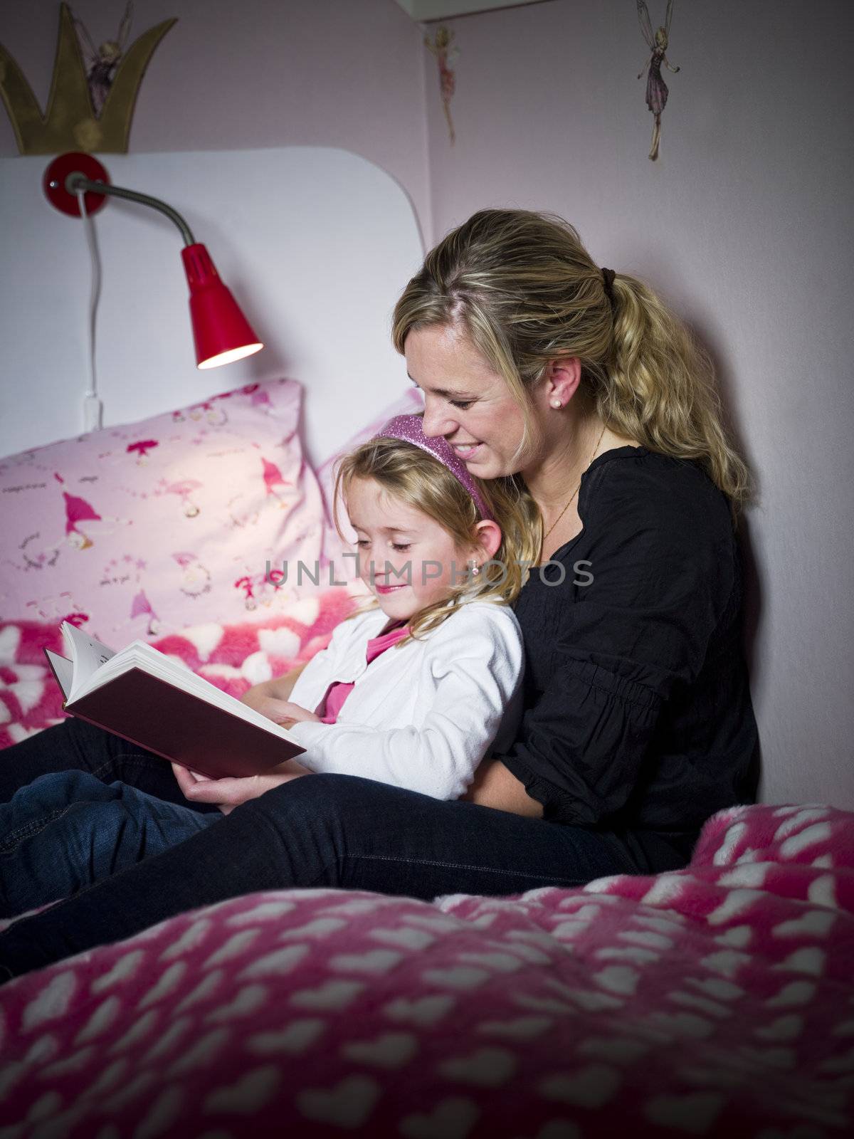 Mother and Daughter storytelling sitting on the bed