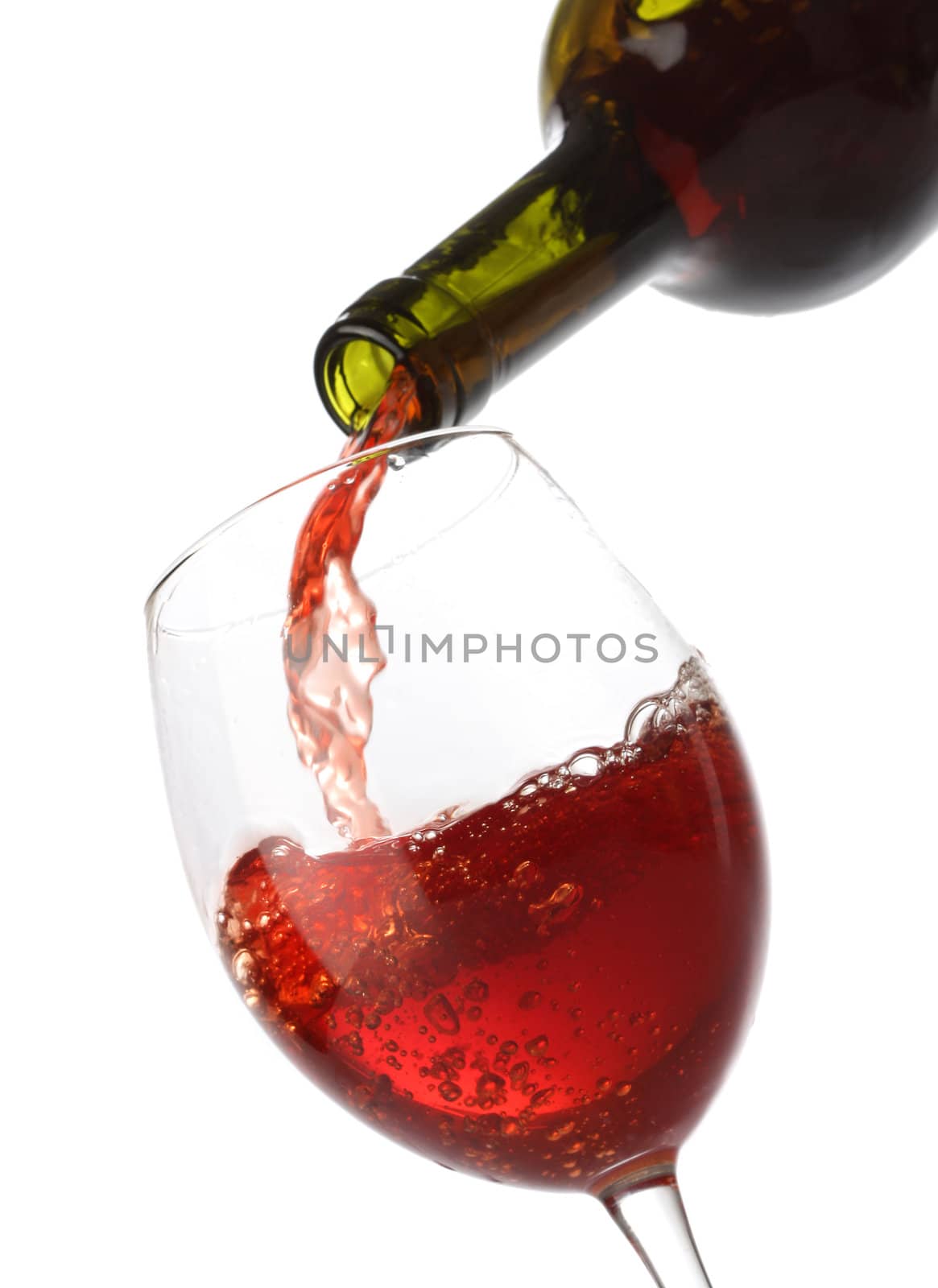 Pouring red wine into a glass isolated on white