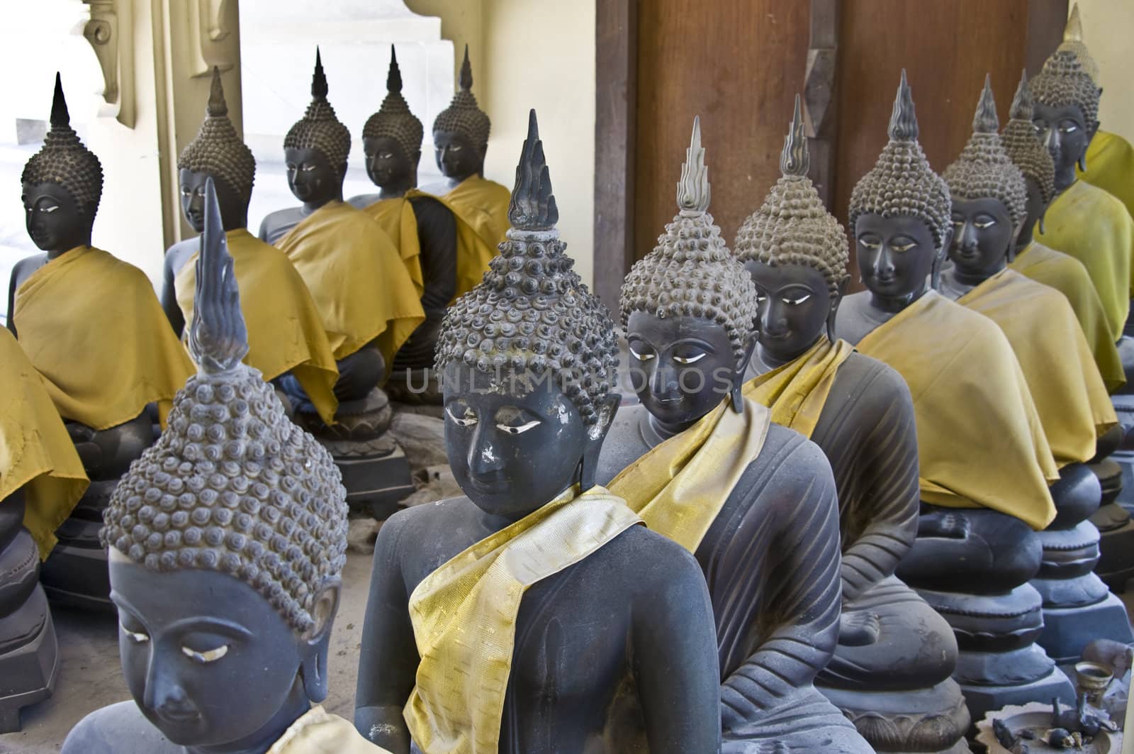 lots of statues of buddha sitting in lines