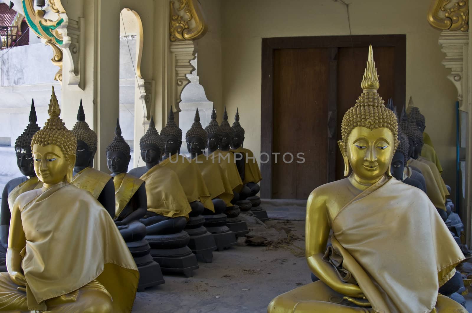 lots of statues of buddha sitting in lines