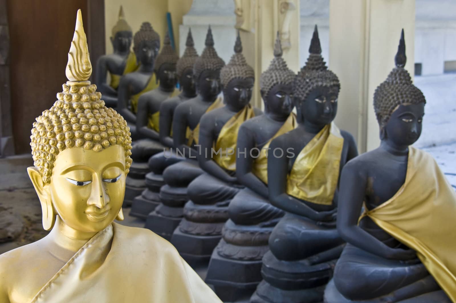 lots of statues of buddha sitting in lines