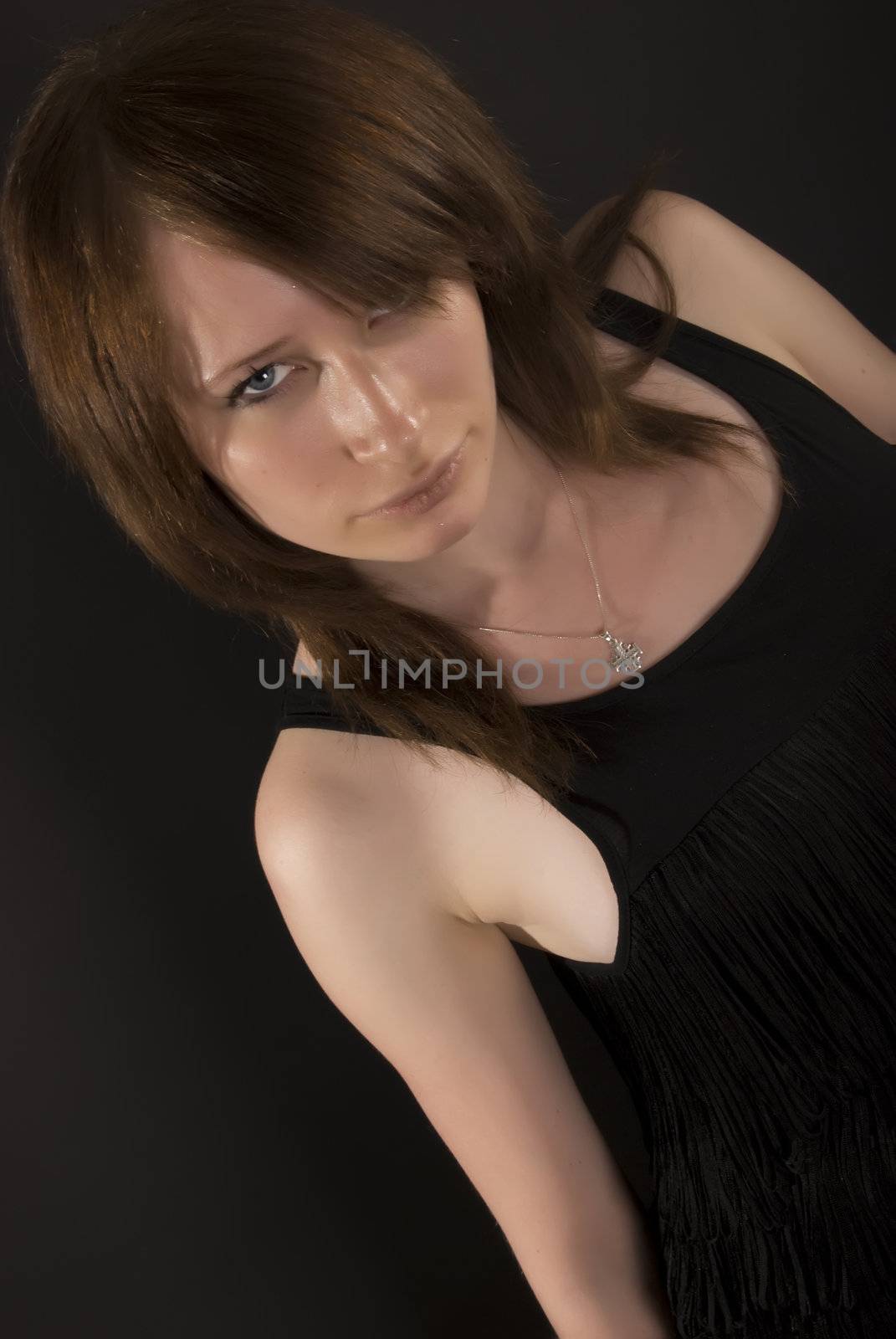 Portrait of a young seductive brunette over black