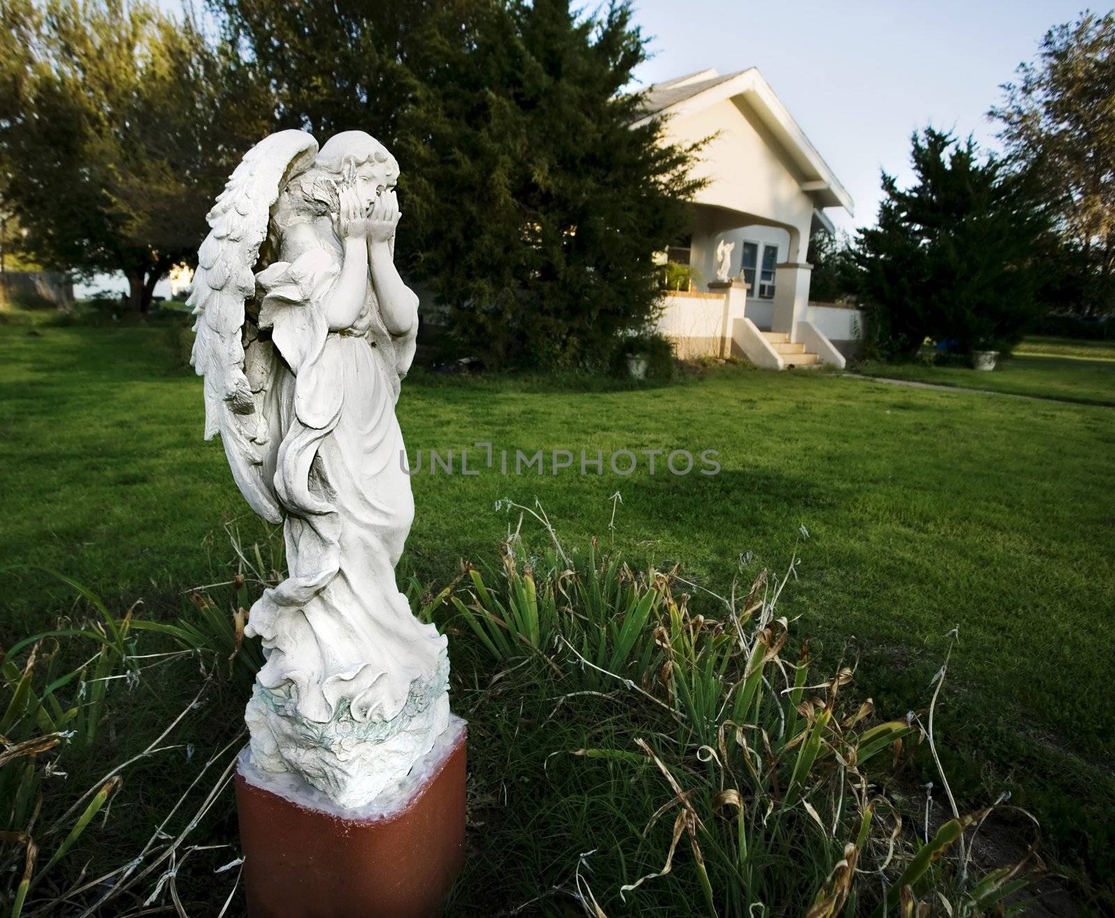 Angel statuary in front of a house