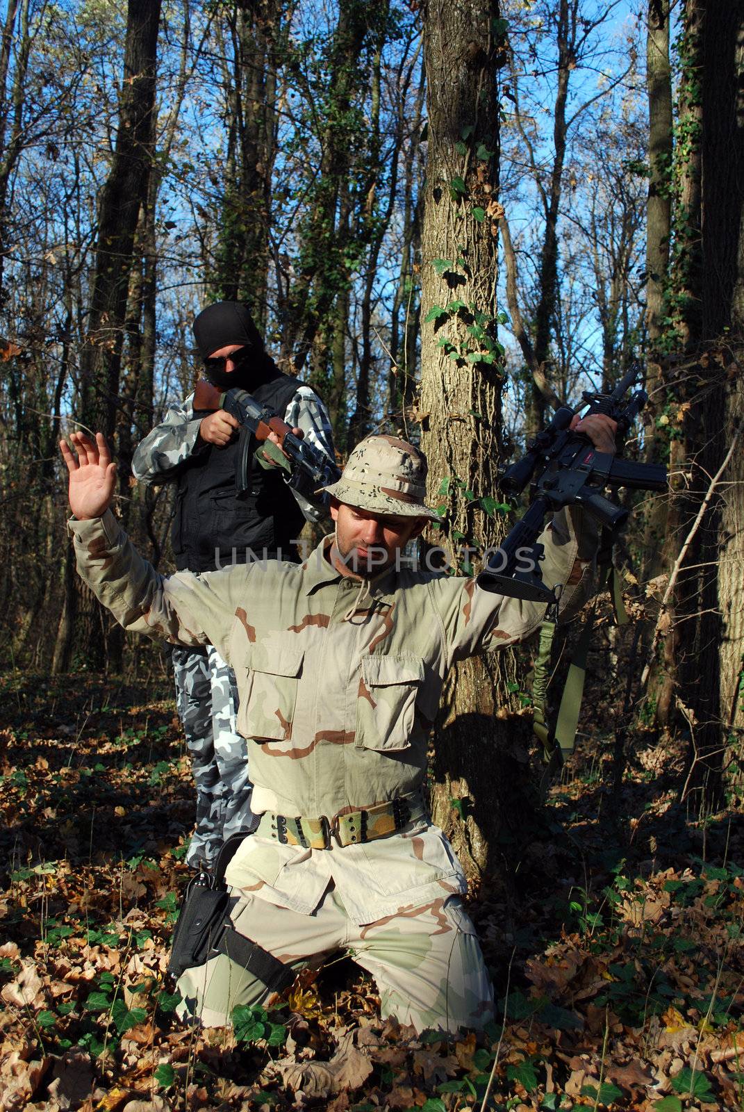 US soldiercriminal taking armed US soldier under arrest with forest behind