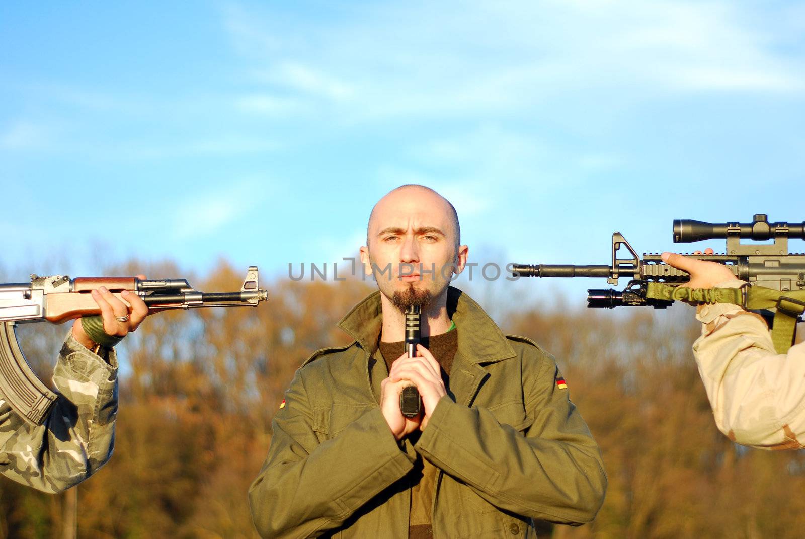 one guerilla soldier with many weapons pointed to his had