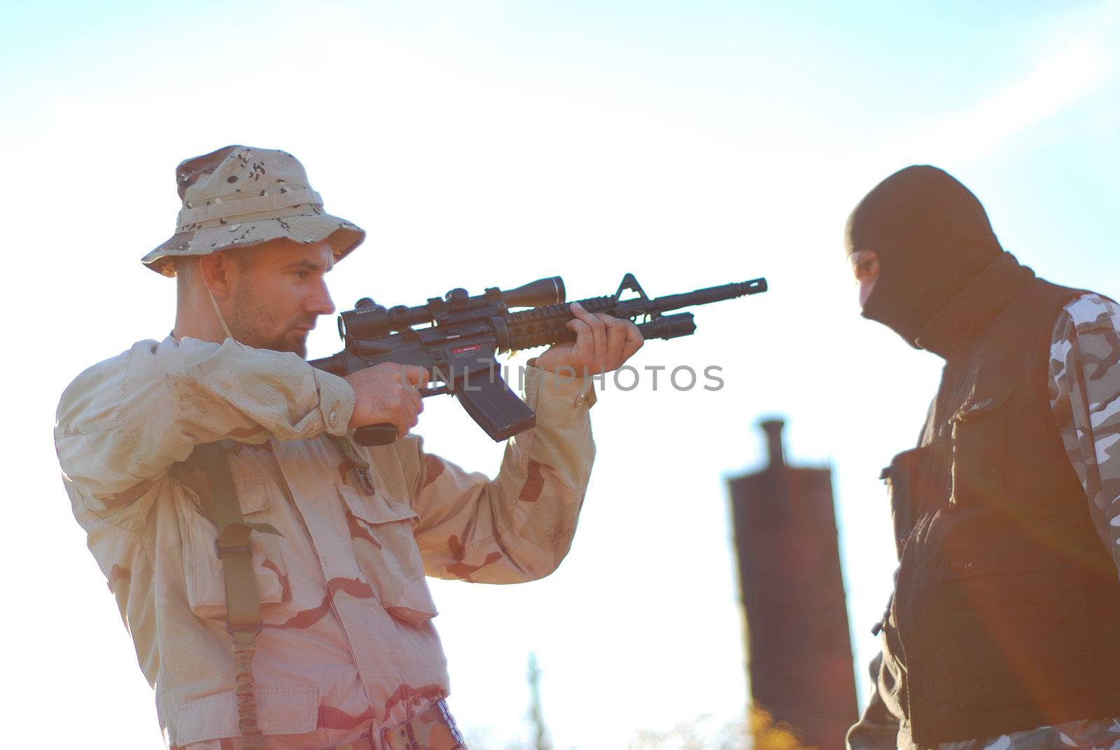 US soldier taking armed criminal under arrest with lens flare effect