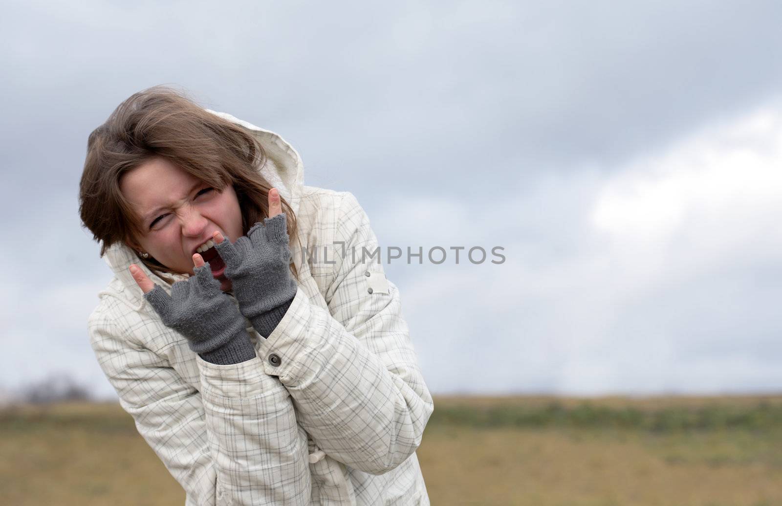 Emotional nice young girl crying on background with autumn dark sky