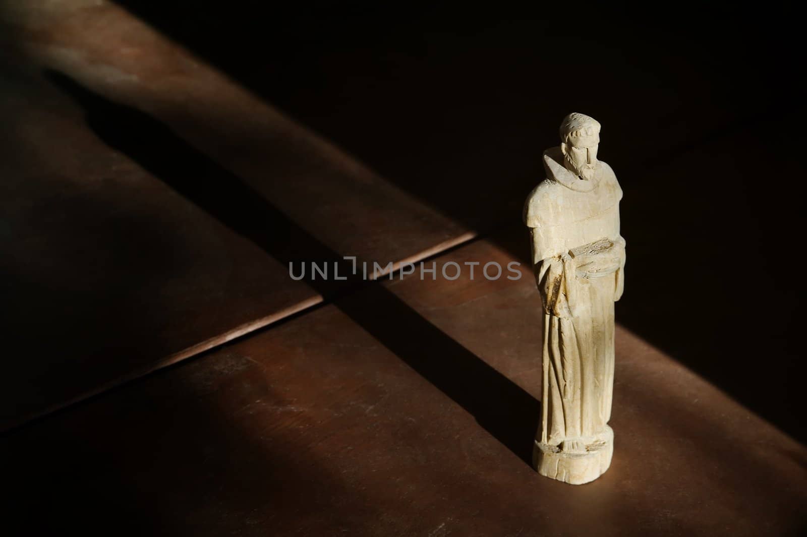 Wooden Statue of St. Francis in Afternoon Light with Shadow