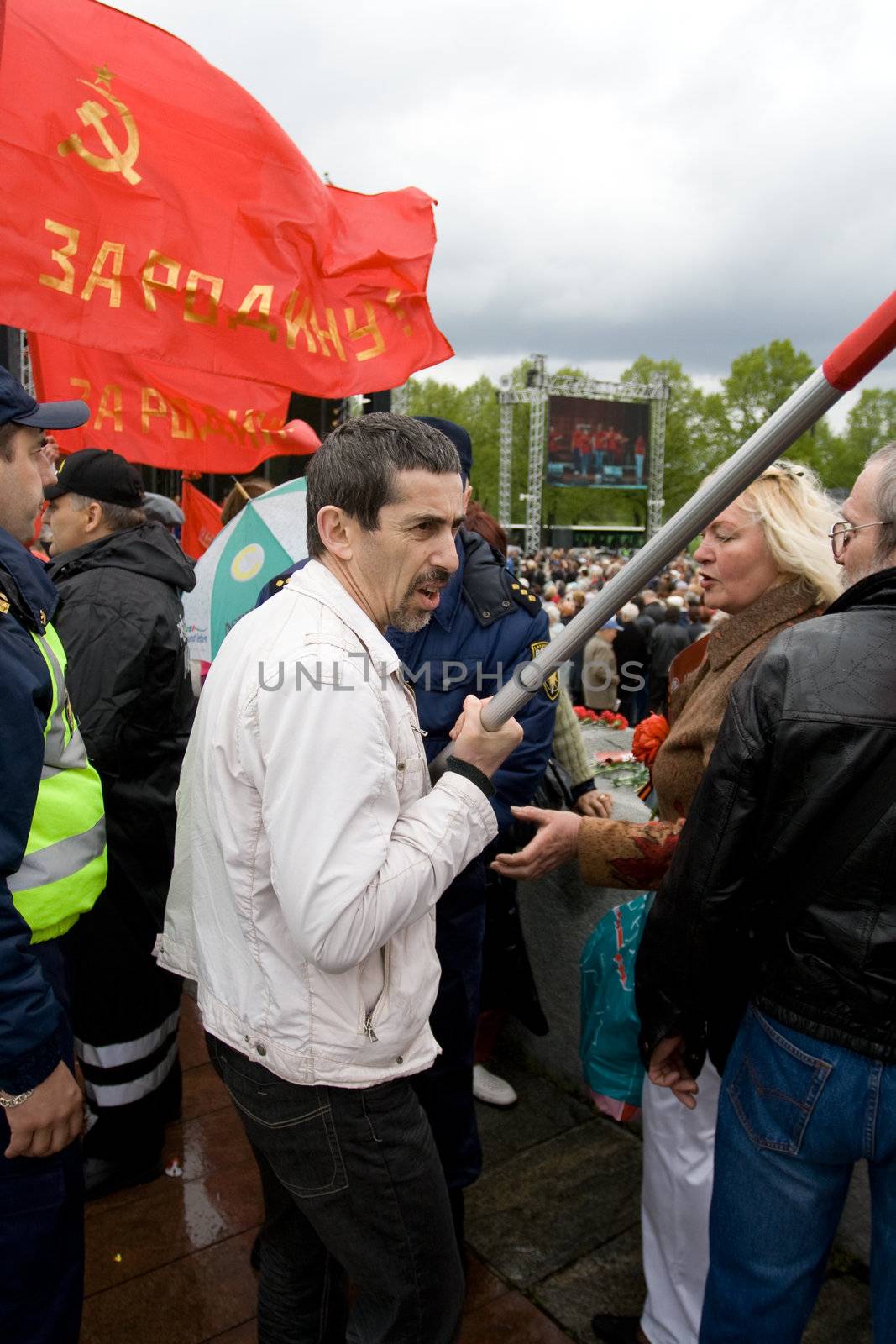 RIGA, LATVIA, MAY 9, 2009: Vladimir Linderman, member of the banned National Bolshevik party (NBP) is arrested for using forbidden Soviet Union flag. Celebration of May 9 Victory Day (Eastern Europe) in Riga at Victory Memorial to Soviet Army