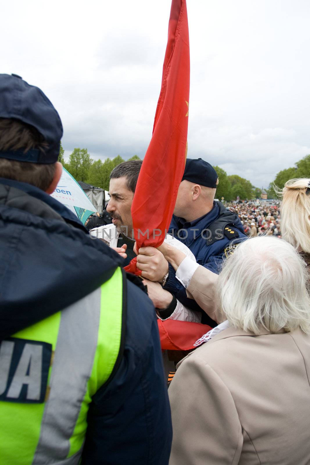 RIGA, LATVIA, MAY 9, 2009: Vladimir Linderman, member of the banned National Bolshevik party (NBP) is arrested for using forbidden Soviet Union flag. Celebration of May 9 Victory Day (Eastern Europe) in Riga at Victory Memorial to Soviet Army