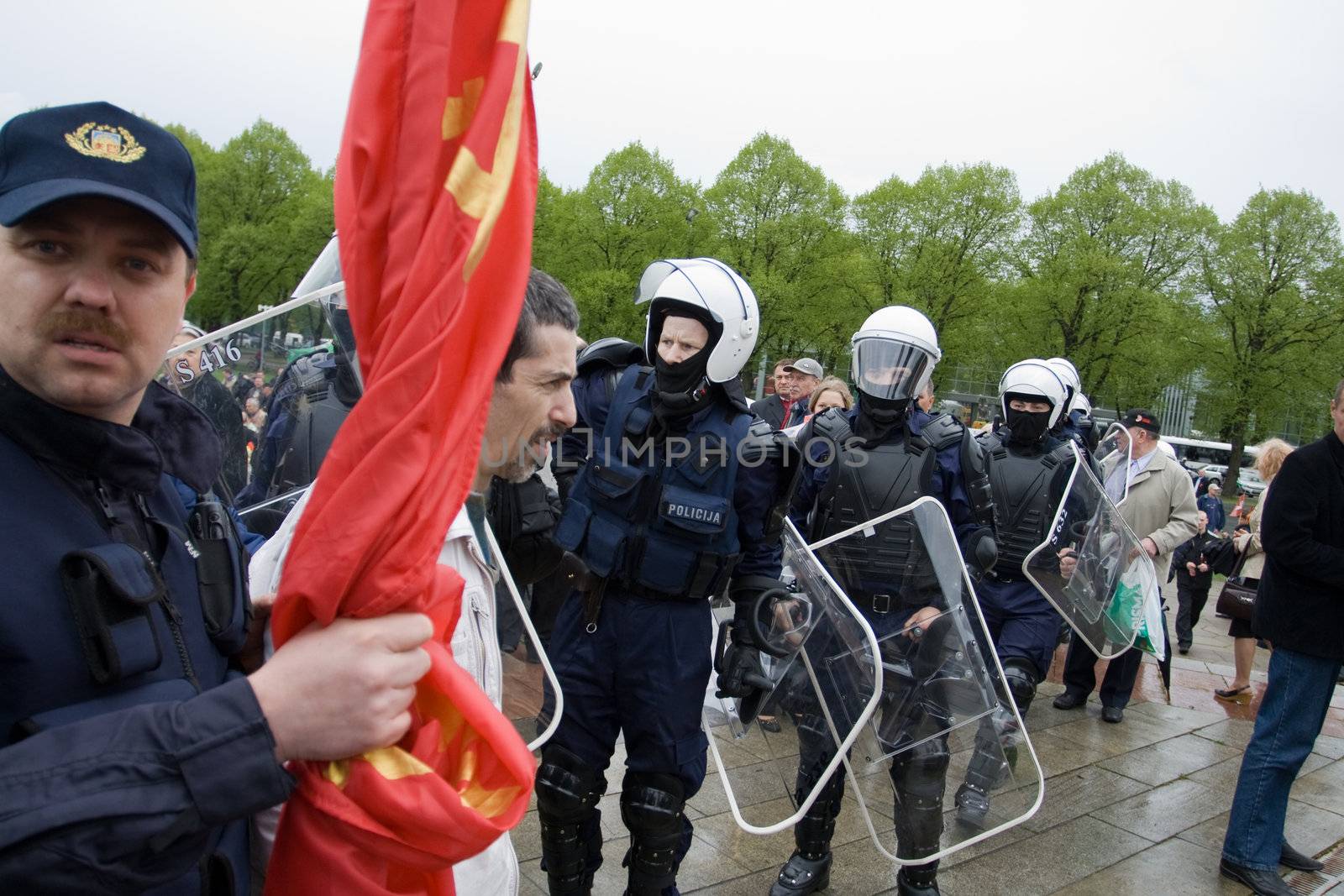 RIGA, LATVIA, MAY 9, 2009: Vladimir Linderman, member of the banned National Bolshevik party (NBP) is arrested for using forbidden Soviet Union flag. Celebration of May 9 Victory Day (Eastern Europe) in Riga at Victory Memorial to Soviet Army