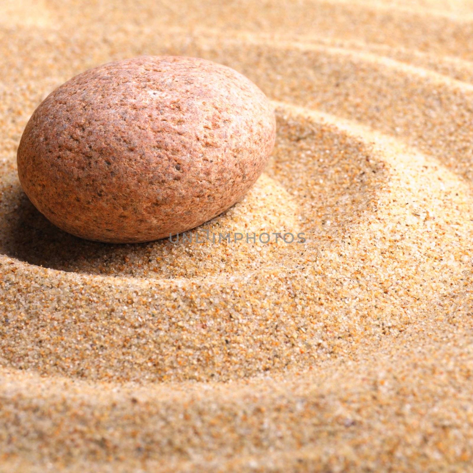 zen garden with stone or pebble on sand with leaf