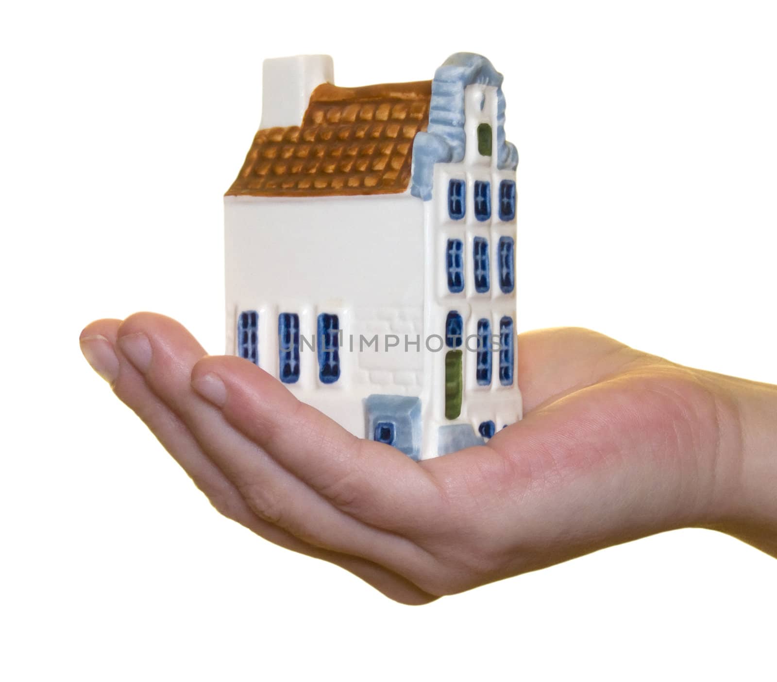 Miniature house in hand on a white background