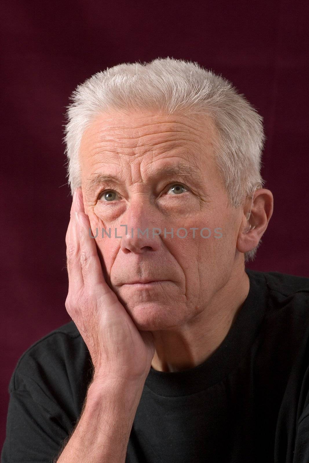 Handsome older man casually dressed, leaning on his hand