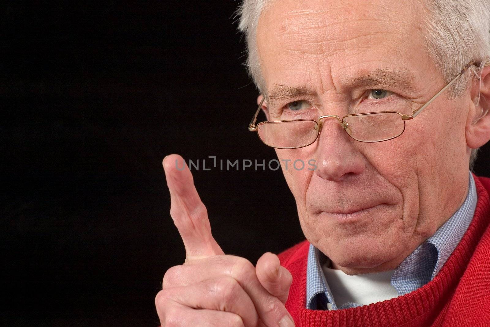 Senior man holding up his finger in a warning