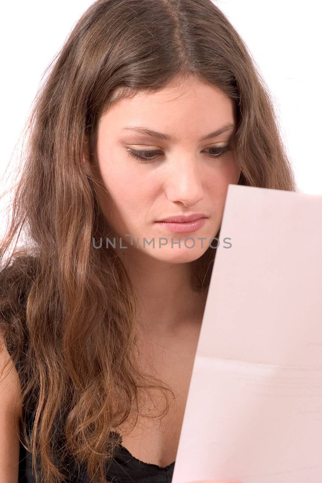 Beautiful young teenager reading a letter with bad news