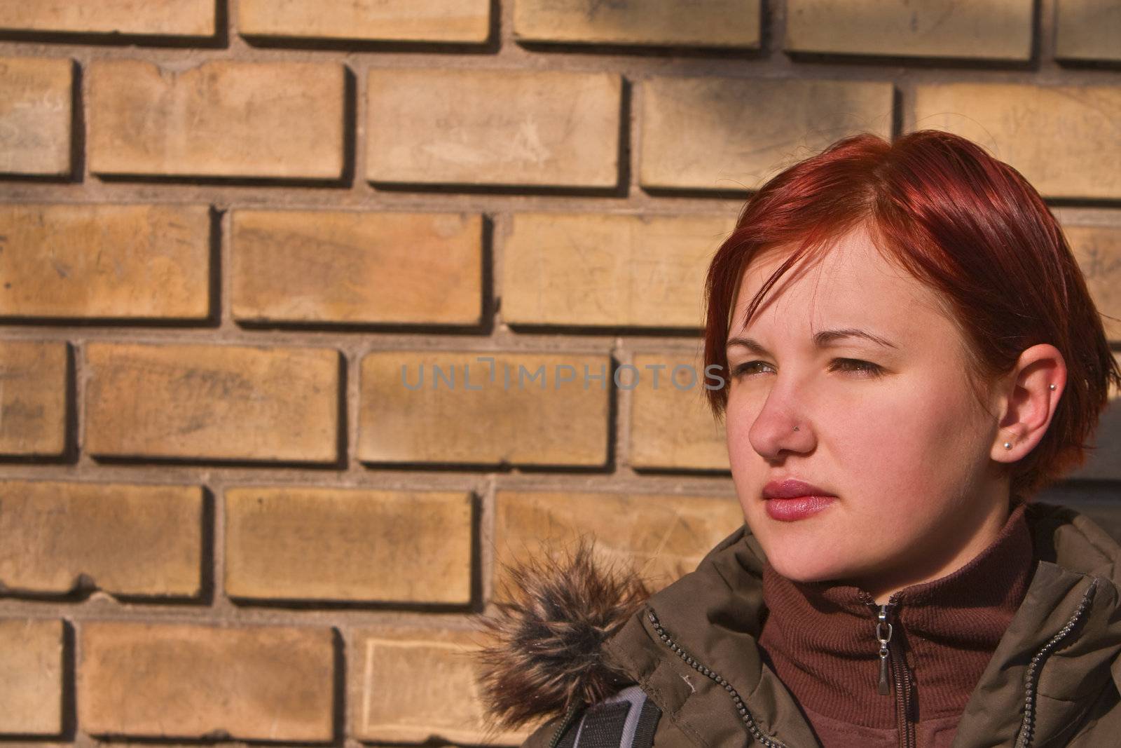 Portrait of a redheaded teen girl against a wall.Shot with Canon 70-200mm f/2.8L IS USM