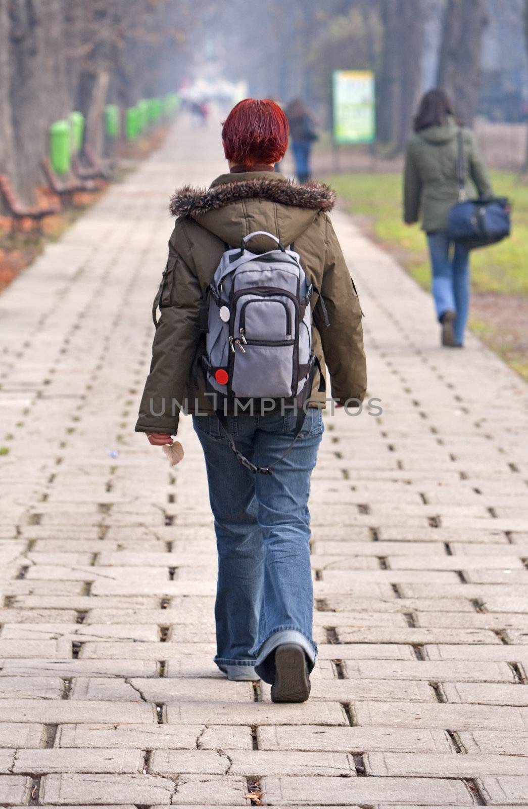 Redhead teen with backpack walking in an autumn park.Shot with Canon 70-200mm f/2.8L IS USM