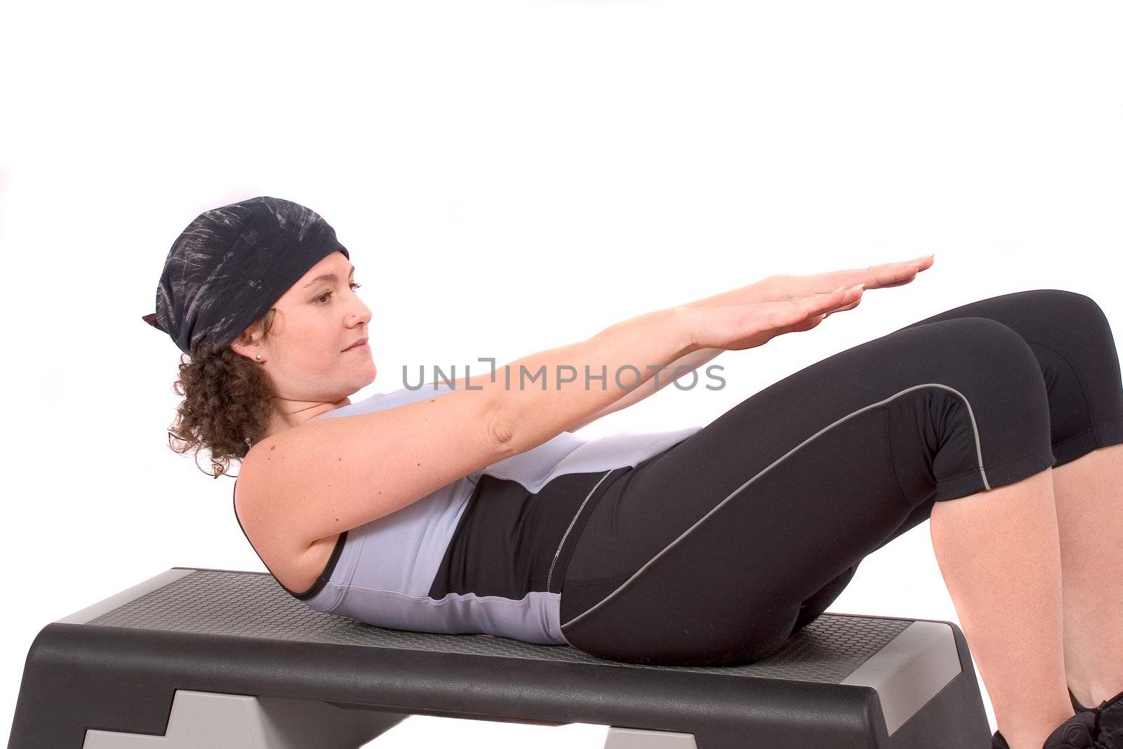 Young woman doing abdominal crunches on white background