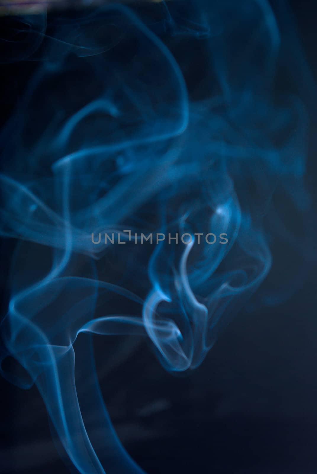 Colored smoke wisps on black background