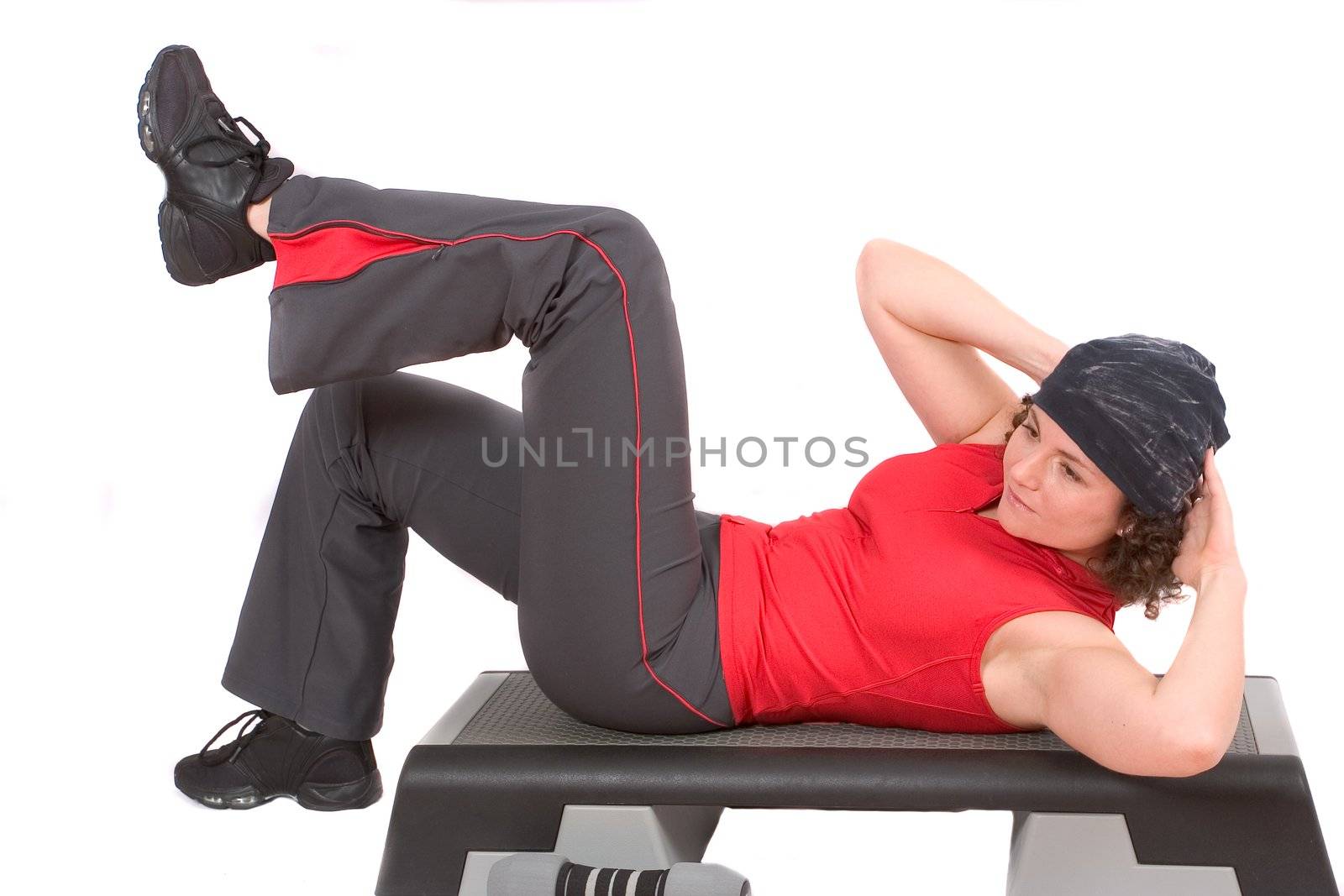 Pretty woman doing abdominal crunches while lying on a step