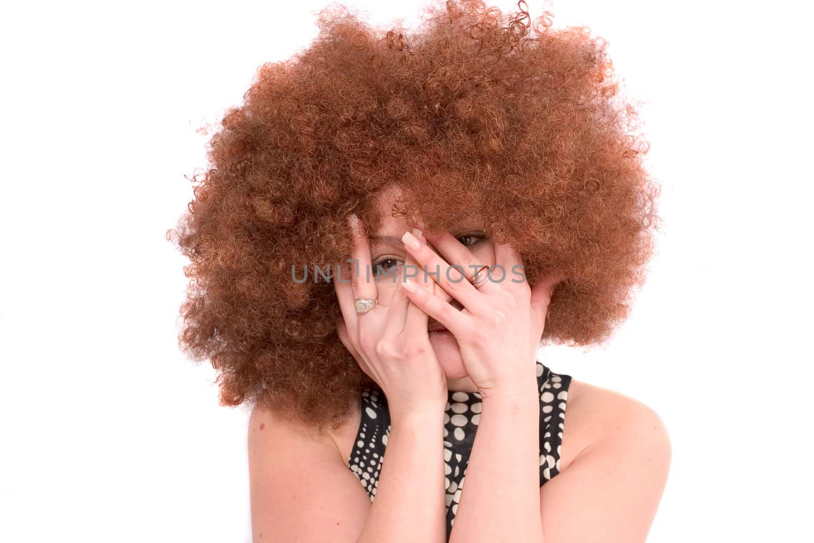 Pretty girl with red afro wig hiding her face in her hands