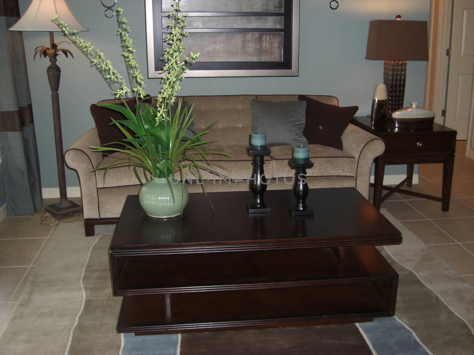 An elegant looking lounge room with a matching color scheme of soft pale blue, rich brown, beige and silver.