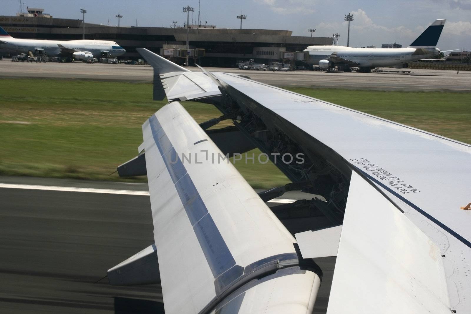 the wing of an airplane that speeds down after landing at manila airport
