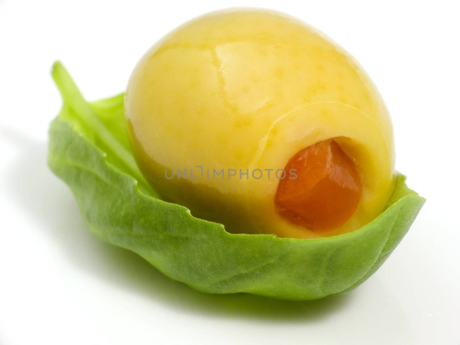 Macroshot of an olive on a leaf of basil