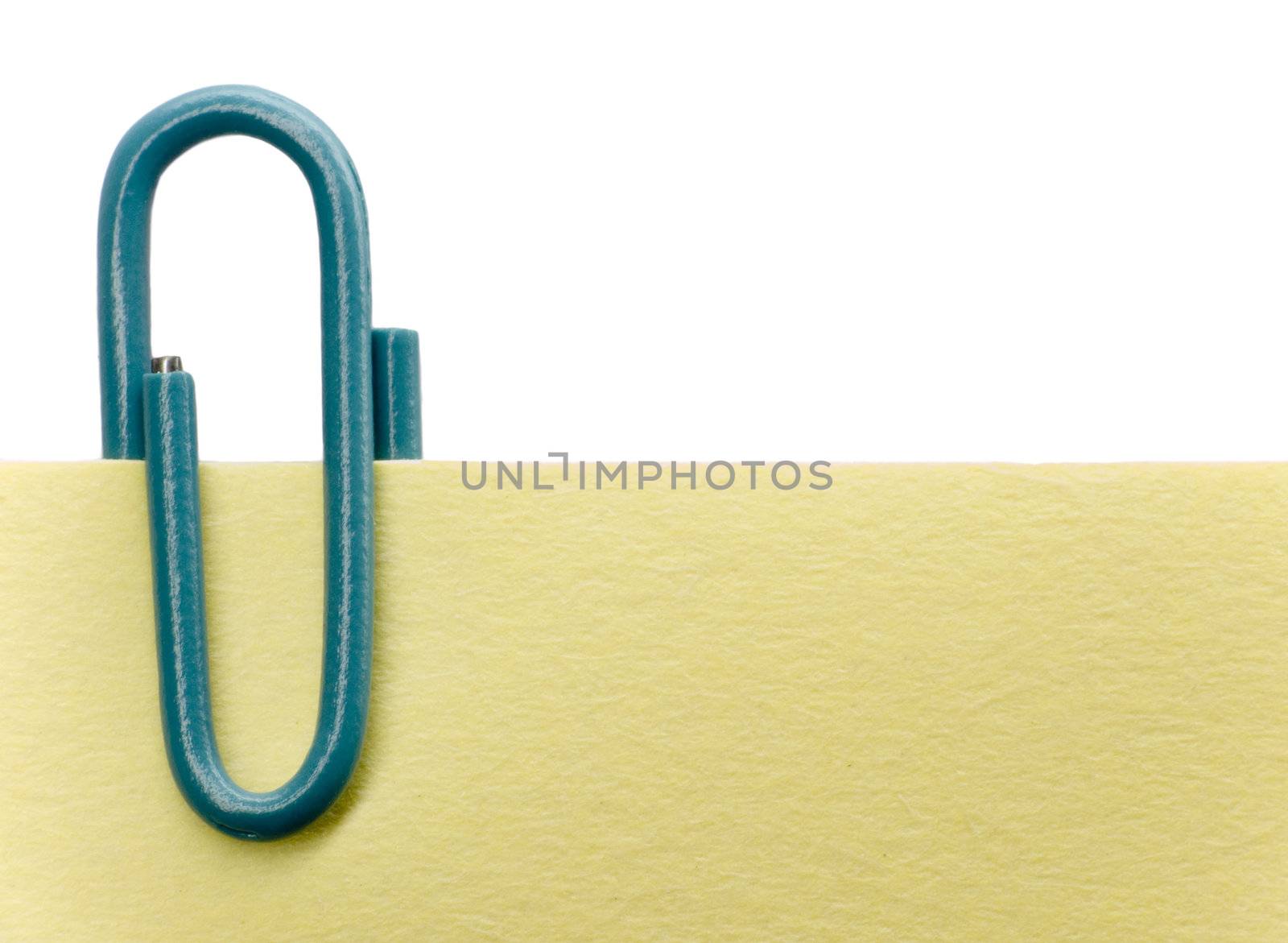 Blue paperclip on a yellow note with white background