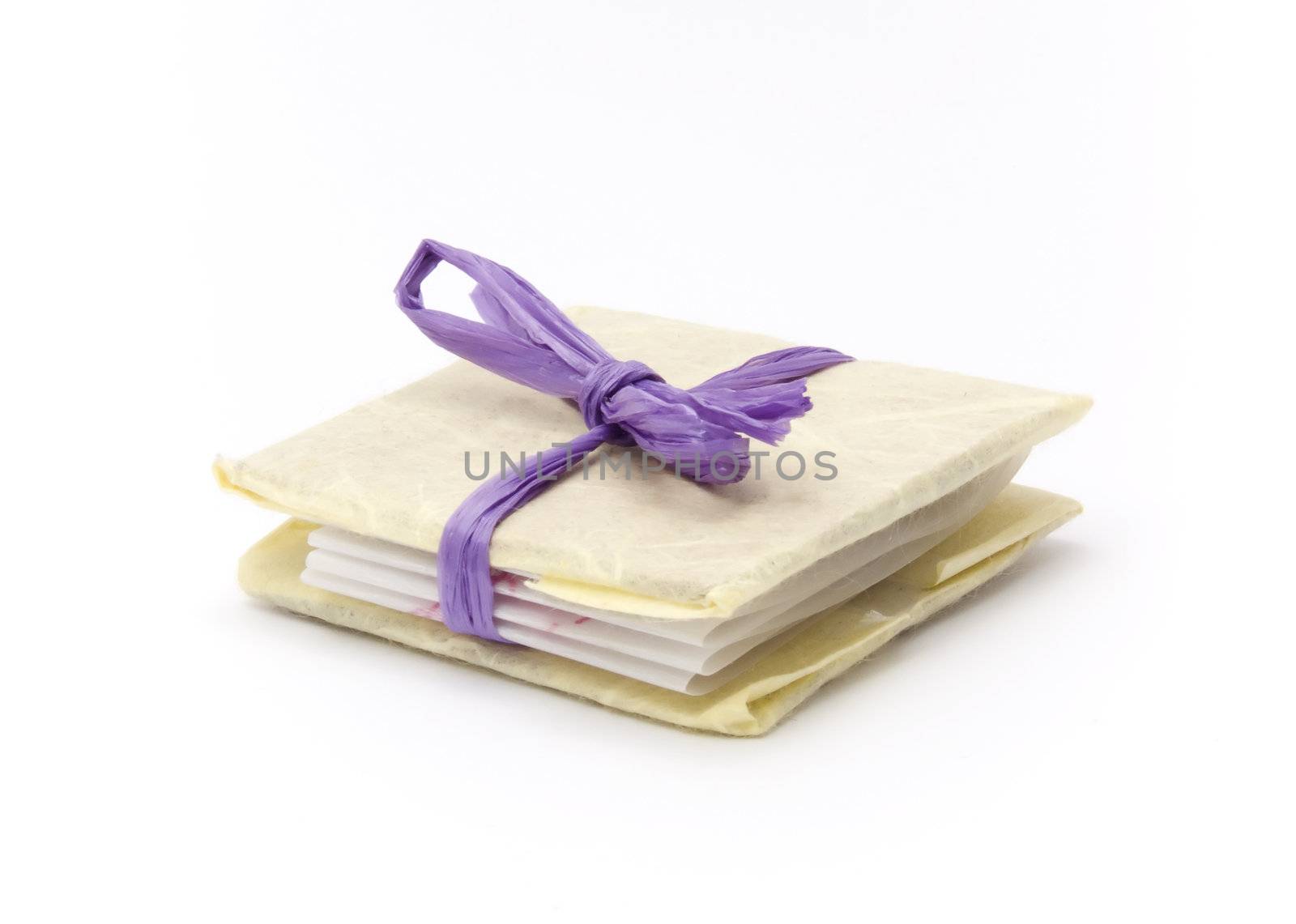 A small book tied with a purple ribbon like a present