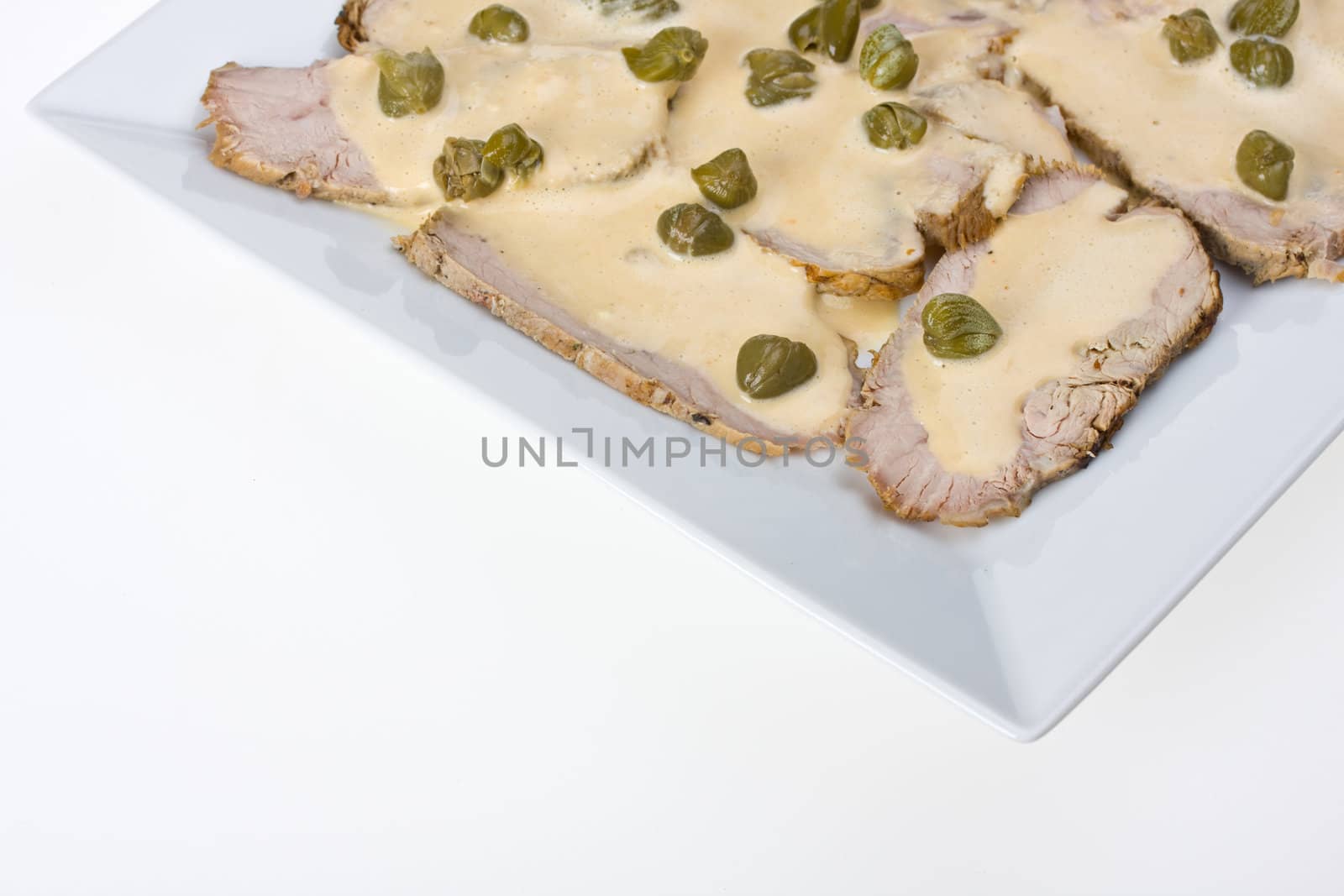 detail of vitello tonnato on a plate by bernjuer