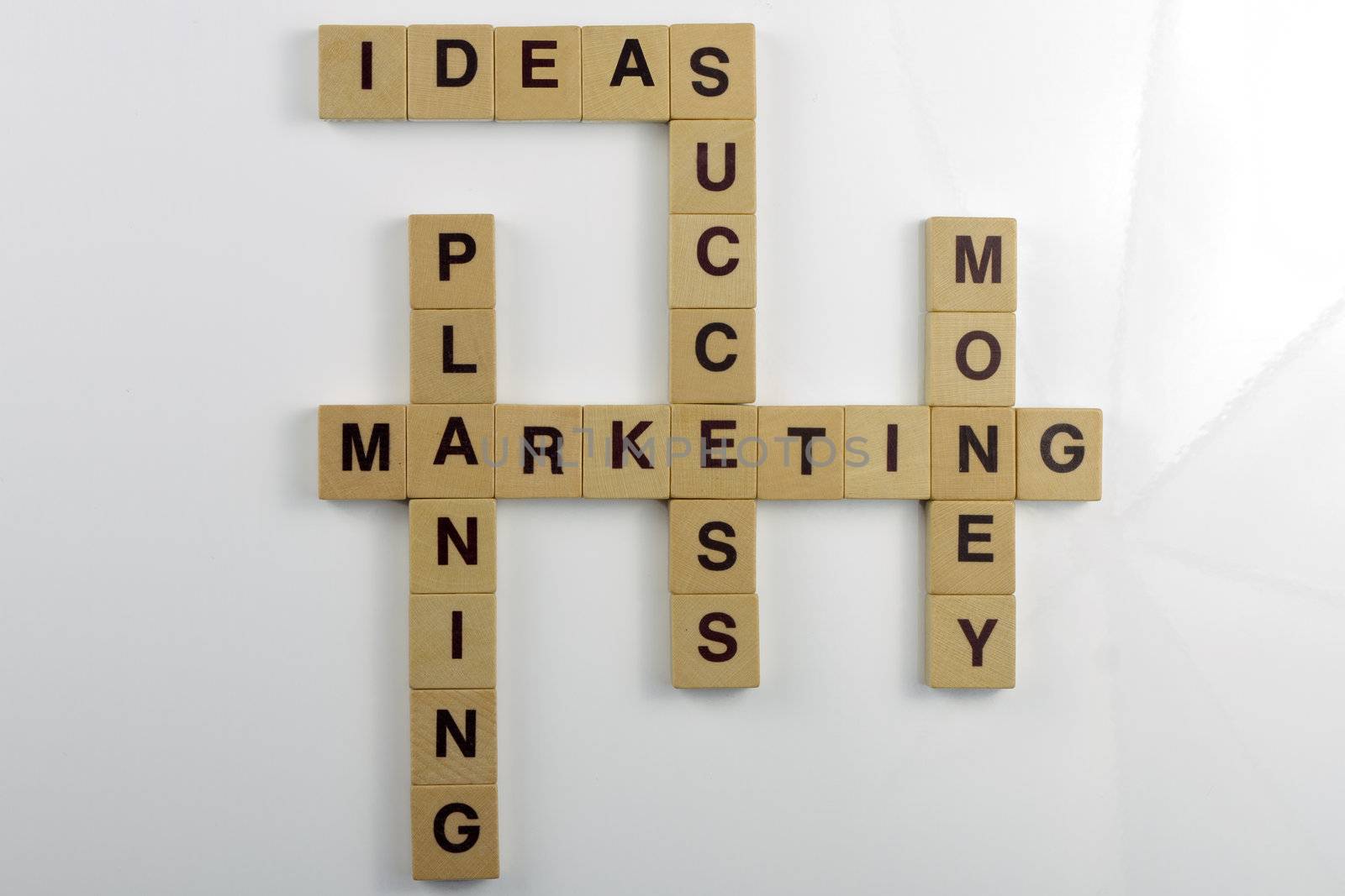 Wooden letter magnets arranged as a crossword with business terms