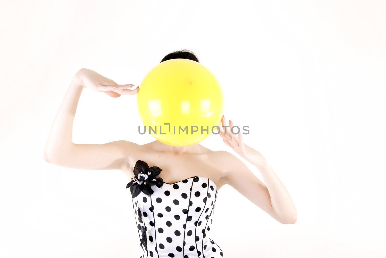 Portrait of a young beautiful brunette posing with yellow ball