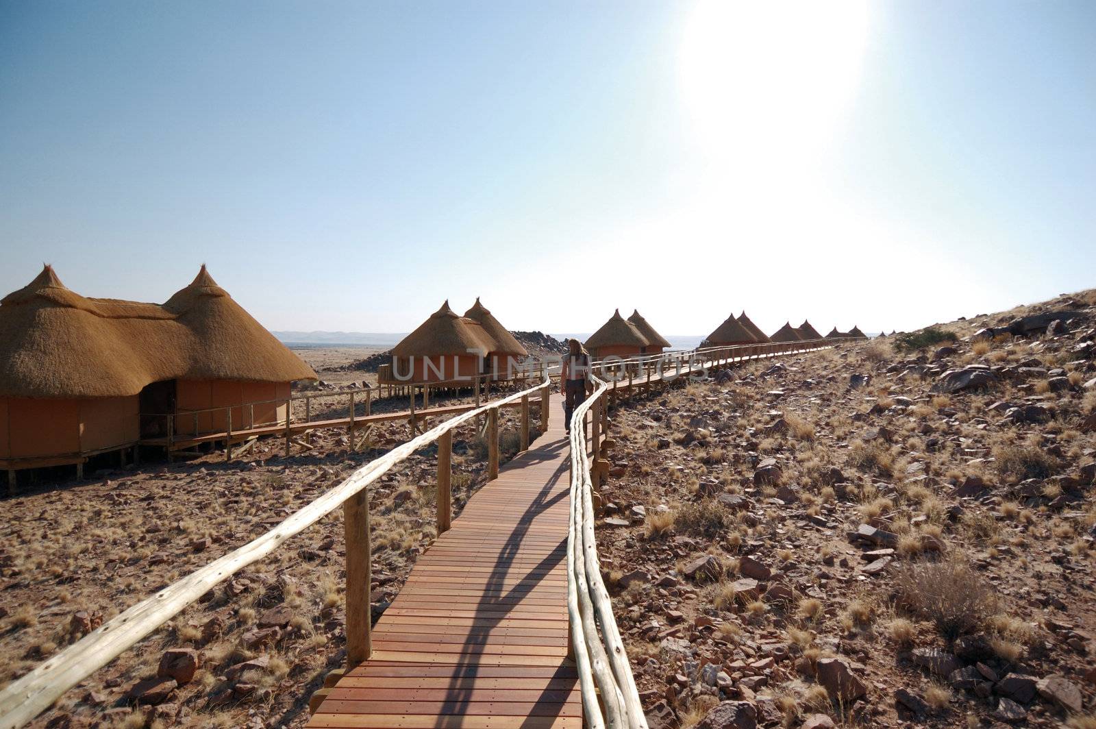 Woman on the wood bridge look at the desert - Safari Lodge