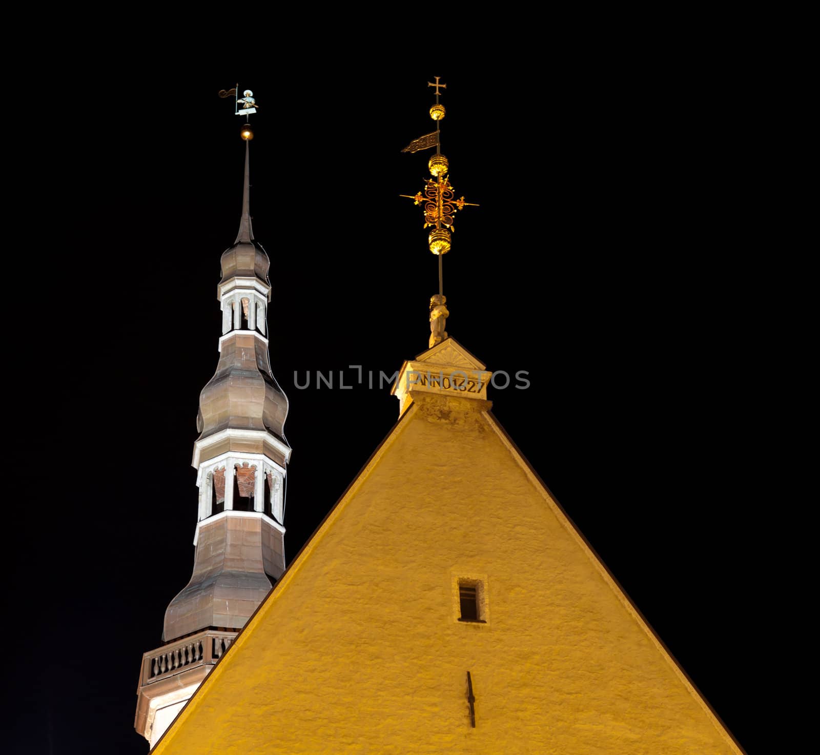 Tallinn town hall at night in Raekoya square showing the floodlit spire and tower of the hall