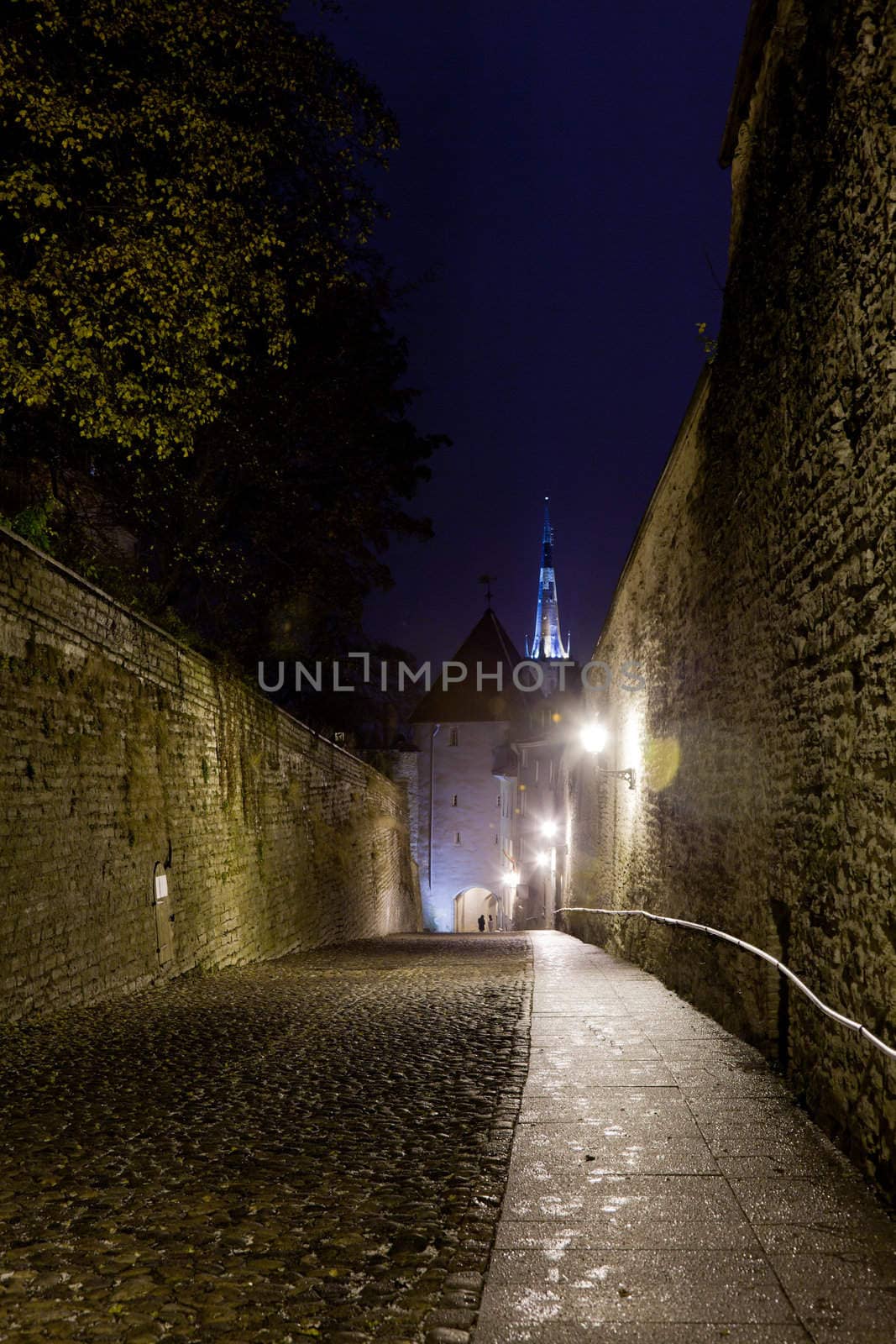 Luhike street leads to the old town of Toompea in Tallinn Estonia on a wet dark night