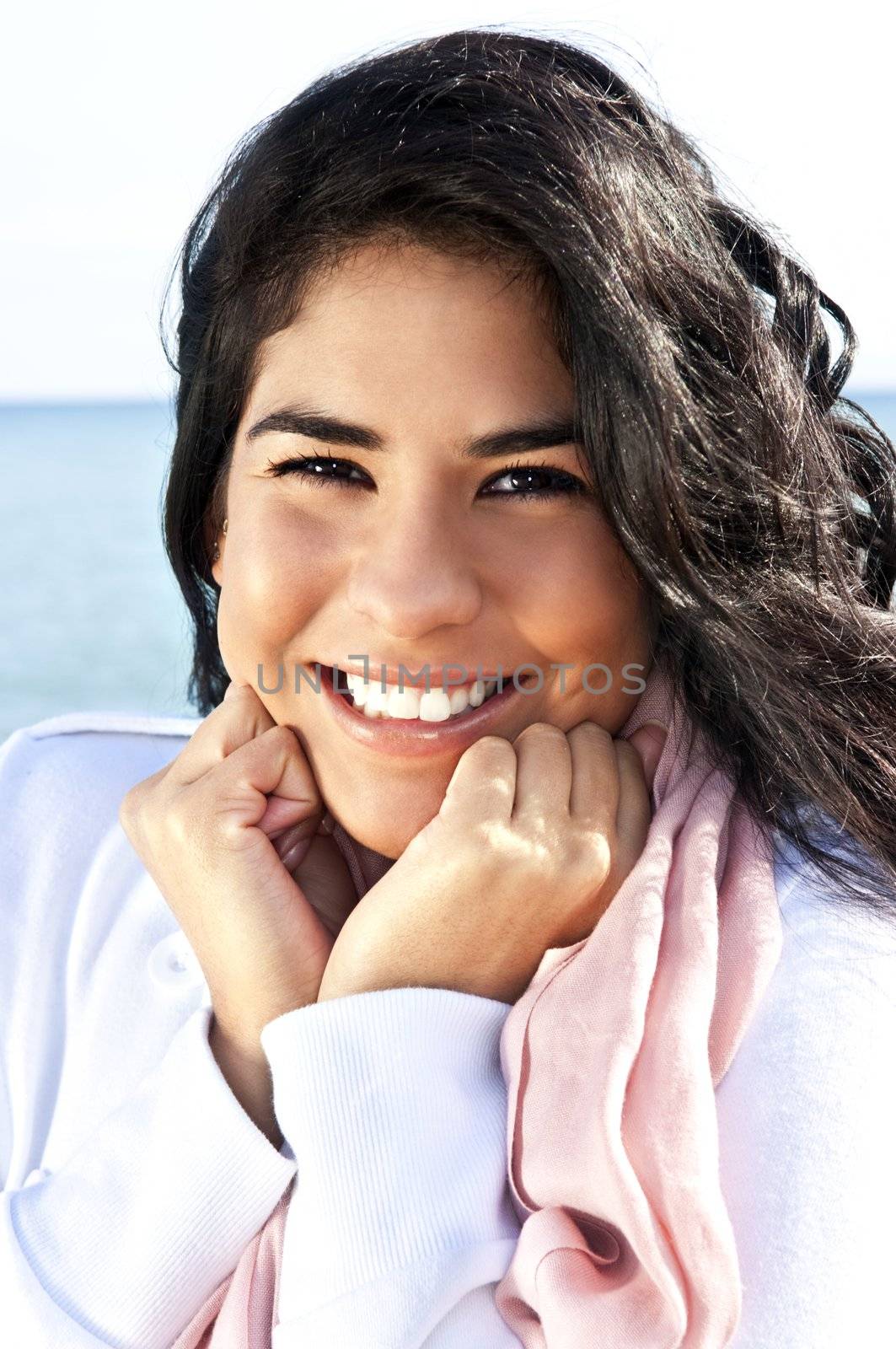 Portrait of beautiful smiling native american girl with hands at her face